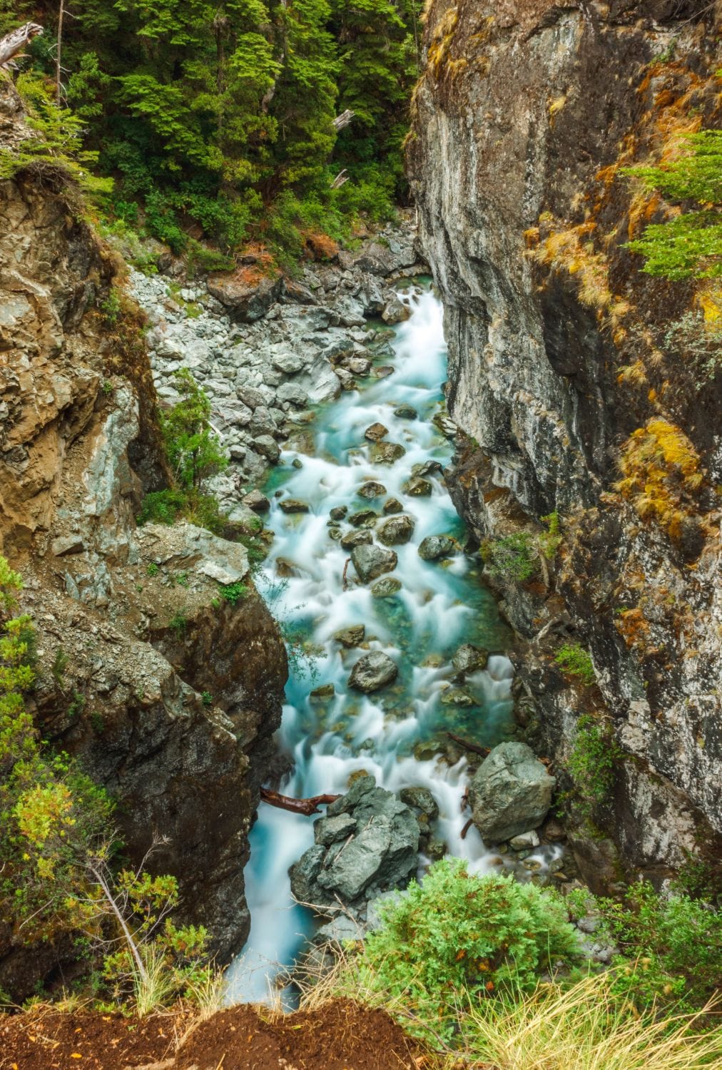 Río de deshielo que corre entre paredes de roca y bosque